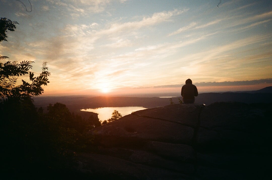 person meditating outdoors at sunrise