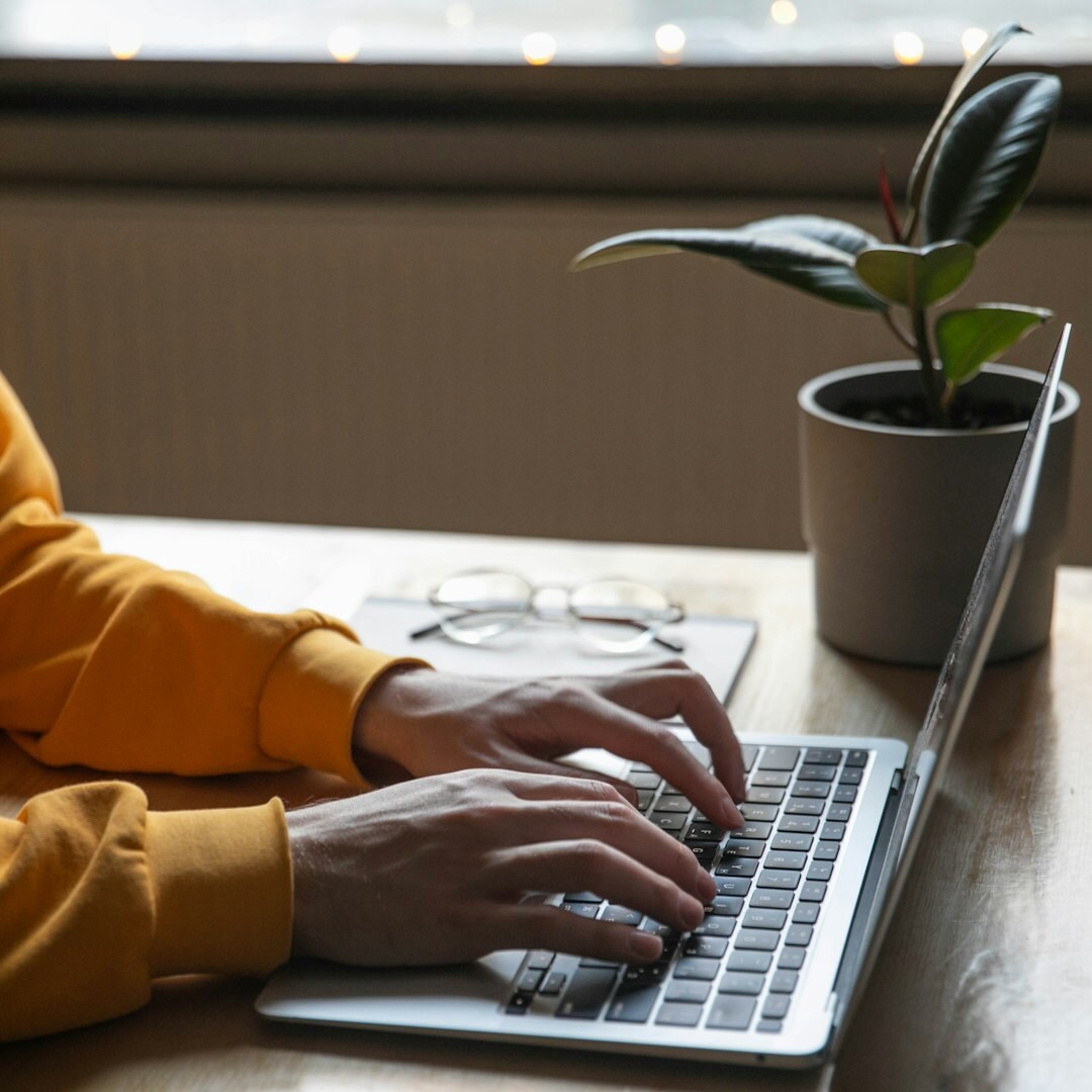 Young woman typing on a laptop at a desk
